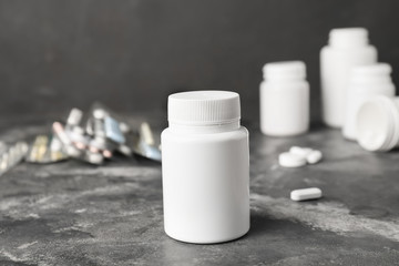 Bottle with pills on grey background