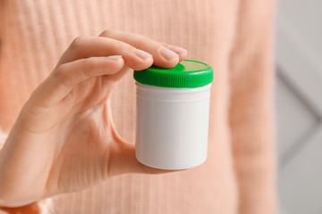 Woman with bottle of pills, closeup