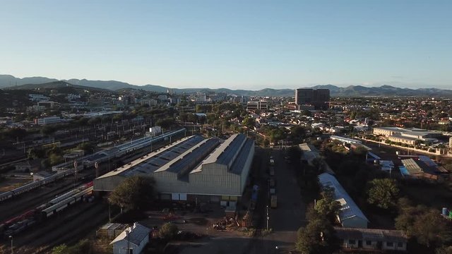 4K aerial Windhoek capital main railway station depot sheds, workshops and railway lines with trains parked area at bright sunrise drone video in Khomas Region, central Namibia