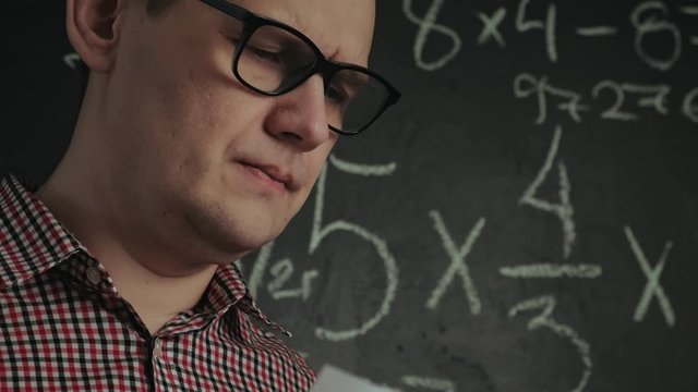 man writes math formula on blackboard