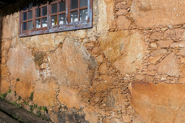 Typical sandstone wall of an old colonial building with window, Minas Gerais, Brazil
