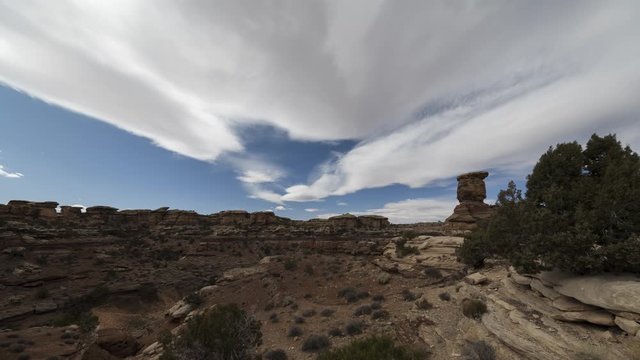 A wide timelapse looking past down into Big Spring Canyon Overlook in Canyonlands National Park as clouds flow overhead on a winter morning.