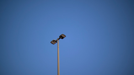 A light in a parking lot on a clear day