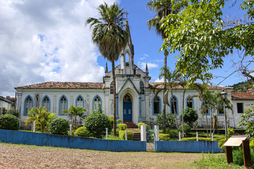 Colonial church in the historical town of Serro with palm trees in sunshine, Minas Gerais Brazil
