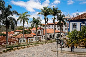 View to traditional houses and palm tree lined street in historic center of Diamantina on a sunny day, Minas Gerais, Brazil