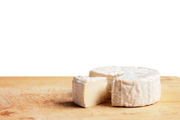 Brie. Cheese cubes that are sliced out on the wooden floor.