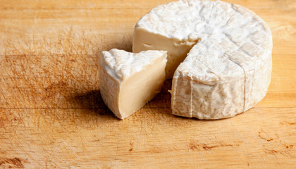 Brie. Cheese cubes that are sliced out on the wooden floor.