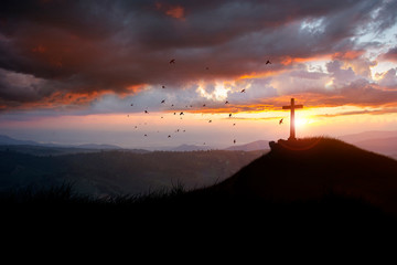 Jesus Christ cross. Easter, Concept conceptual black cross religion symbol silhouette in grass over sunset or sunrise sky