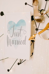 just married sign with wedding dress and shoes on white wall background