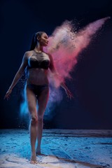 Slim woman in color dust cloud portrait