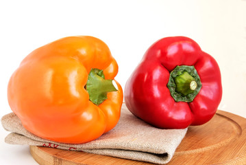 Colorful fresh peppers lie on a kitchen board on a napkin. 