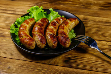Tasty grilled sausages on a wooden table