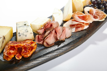 Cheese plate with meat and grapes