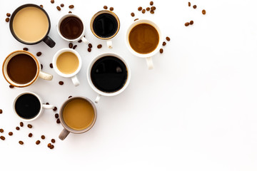 Cups of hot drinks on white table top-down space for text