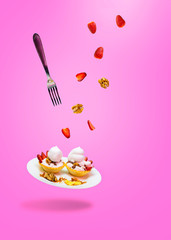 cake on a plate with levitating fork strawberry nuts
