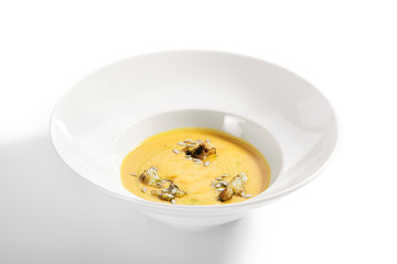 Pumpkin soup in white bowl