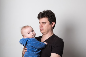 Young dad with a baby. Selective focus. Cute dad is played with a baby.