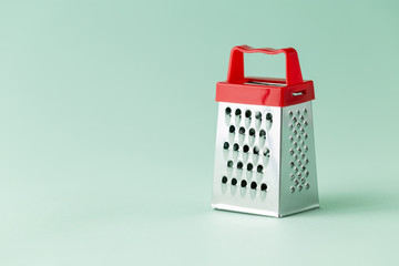 One single cheese grater on a green background