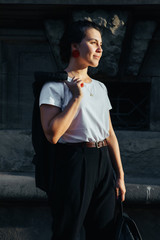 portrait of young pretty woman at city street sunset light