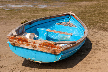 Obraz premium Fishing dinghy beached by the tide on Knysna lagoon