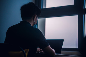 An asian men is working from home during Coronavirus or Covid-19 quarantine, coronavirus covid 19 infected patient in coronavirus covid 19 quarantine room using computer