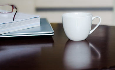 Hot coffee and books on a wooden table