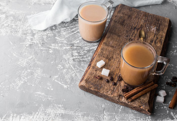 Obraz na płótnie Canvas Cooled coffee with milk, cinnamon sticks, coffee beans, sugar, spoon on the table.