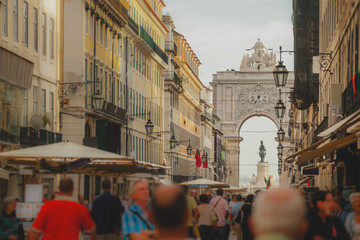 Rua Augusta with the well known arch or Arco da Rua augusta with crouds of tourists looking by on a summer day in Lisbon, Portugal. - obrazy, fototapety, plakaty