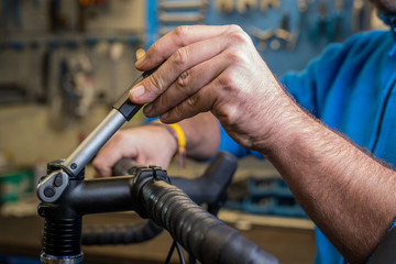 Tightening of a bicycle handlebar stem with the use of a small torque wrench. Proper way to tighten a bicycle stem. Bicycle service in a worshop.