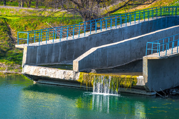 Water flows down the concrete spillway chutes into the lake
