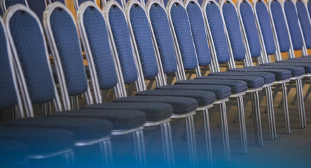Fototapeta premium Row of blue chairs with white dots and aluminium frame on a conference or a meeting. Row of modern blue chairs in a conference hall.