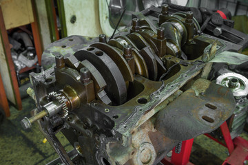 View of the crankshaft of an old disassembled car engine.