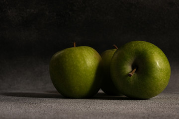 Juicy green apples on concrete surface