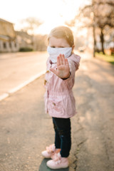 Stop the coronavirus and virus epidemic diseases. Healthy child in medical protective mask showing gesture stop. Health protection and prevention during flu and infectious outbreak.