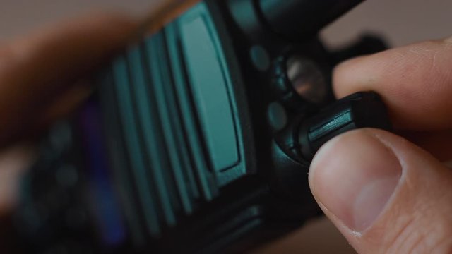 Hand turn on the walkie-talkie indoors close-up macro