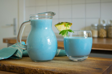 Food photography of a healthy  blue spirulina pina colada drink on a kitchen table
