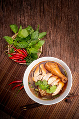 Chicken noodle soup on wood table, Chicken soup with noodles and vegetables in bowl over rustic wooden background