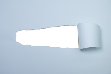 Pastel blue torn paper with hole revealing white copy space in centre
