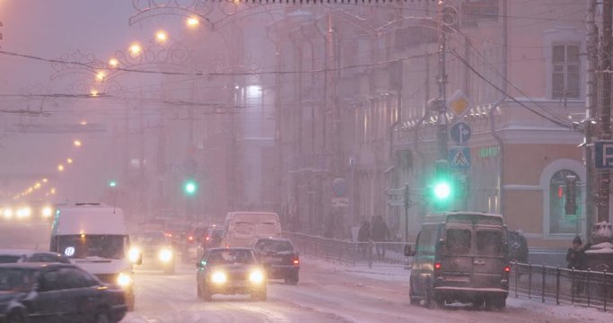 Gomel, Belarus - January 28, 2018: City Traffic On Sovetskaya Street In Winter Snowy Snowstorm Evening Time. Set