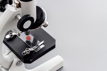 Research with microscope. Laboratory backround with blood sample on grey table copy space