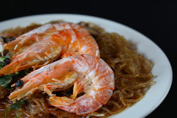 Baked shrimp with vermicelli, Chinese Style Food, close-up view on black background
