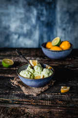 lemon, lime and mint ice cream in bowl on wooden table, refreshing seasonal dessert