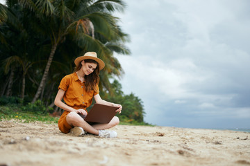 woman with laptop on the beach