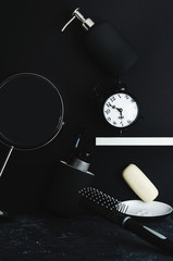 Morning hygiene supplies are scattered in disarray on a black background. The concept of the...