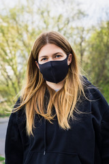  Close up of young woman with surgical mask on face against SARS-CoV-2.