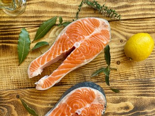 Red fish fillet with vegetables and spices on wooden cutting board