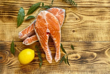 Two raw fresh salmon or trout steaks,  with lemon