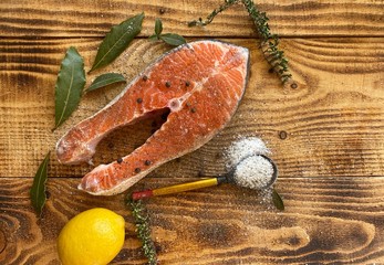 raw fresh salmon or trout steaks, with lemon,  on a wooden background