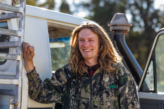 Young country bloke leaning on ute