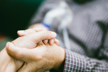 Holding hands for support with senior man  using medical equipment for inhalation with respiratory mask, nebulizer